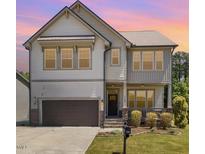 Charming two-story home featuring a cozy front porch, complemented by a well-maintained lawn at 7508 Channery Way, Raleigh, NC 27616