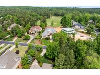An aerial view of a neighborhood showcasing lush landscaping, well-maintained streets, and a golf course in the background at 77 Ruffed Grouse, Chapel Hill, NC 27517