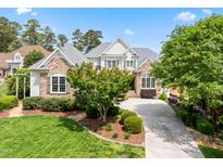 Charming stone and siding home with a well-manicured front lawn and a paved driveway leading to the entrance at 77 Ruffed Grouse, Chapel Hill, NC 27517