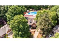 Stunning aerial view of home with pool, surrounded by lush trees, offering privacy and seclusion at 7901 Farnham Ct, Raleigh, NC 27615