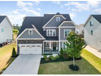 Charming two-story home with gray siding, stone accents, well-manicured lawn, and attached two-car garage at 808 Buckner Ct, Fuquay Varina, NC 27526