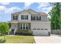 Charming two-story home with gray siding, black shutters, stone accents, and a well-manicured front lawn at 8616 Deep Elm Dr, Wake Forest, NC 27587
