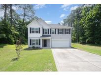 Charming two-story home with a manicured lawn and a two-car garage at 11 Mamie Ferguson Dr, Lillington, NC 27546