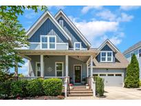 Charming two-story home featuring a welcoming front porch and a well-manicured lawn at 120 Mearleaf Pl, Holly Springs, NC 27540