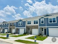 Charming townhomes feature a mix of brick and siding exteriors with attached garages and manicured lawns at 121 N Chubb Rdg, Wilson's Mills, NC 27520