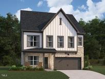 Charming two-story home featuring a mix of siding and stone with an attached two-car garage at 1405 Malcus Ct # 59, Fuquay Varina, NC 27526