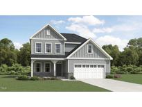 Charming two-story home with gray siding, stone accents, attached two-car garage and well-manicured lawn at 1552 Bright Coral Trl, Wendell, NC 27591