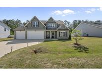 Charming two-story home featuring an attached two-car garage and a well-maintained lawn at 178 Ashpole Trl, Clayton, NC 27520