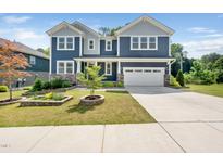 Beautiful two-story home showcasing its blue siding, stone accents, and well-manicured front yard at 1813 Lost Creek Ct, Apex, NC 27539