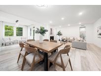 Bright open-concept living and dining area with wood floors and a cozy fireplace at 1813 Lost Creek Ct, Apex, NC 27539