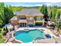 Stunning backyard oasis with a large pool, outdoor kitchen, covered patio, and lush landscaping at 187 Stoney Creek Way, Chapel Hill, NC 27517