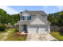 Charming two-story home featuring a two-car garage, well-manicured lawn, and inviting curb appeal at 228 Honeywell Way, Fuquay Varina, NC 27526