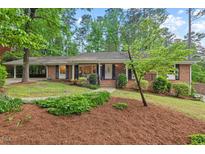 Charming brick home with a well-manicured lawn and mature trees creating an inviting curb appeal at 2508 Sevier St, Durham, NC 27705