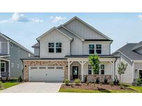 Charming two-story home with white siding, brick accents, and a well-manicured front lawn at 2625 Stonington Dr, Cary, NC 27523