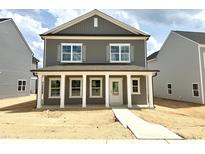 Charming two-story home featuring gray siding, white trim, and a welcoming front porch with classic columns at 2868 Quarry Rd # 167, Rolesville, NC 27571