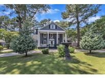 Charming two-story home with classic architectural details and manicured front lawn and garden at 300 S Pine St, Benson, NC 27504