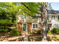 Charming brick and siding townhouse with a vibrant green door and lush landscaping at 3029 Wycliff Rd, Raleigh, NC 27607