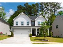 Beautiful two-story home features a well-manicured lawn and attached two-car garage at 303 Forestview Crest Way, Fuquay Varina, NC 27526