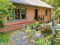 Charming brick home featuring an intricate water feature and manicured landscaping at 307 Clayton Rd, Chapel Hill, NC 27514