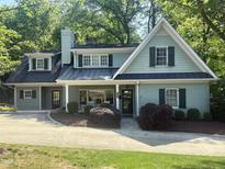 Charming two-story home with a manicured lawn, complemented by lush landscaping and a welcoming, quaint porch at 3504 Rock Creek Dr, Raleigh, NC 27609