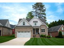 Charming brick home with a two-car garage, well-manicured lawn, and beautiful architectural details at 409 Eagle Ct, Henderson, NC 27536