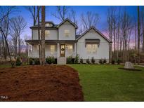 Charming two-story white home with a welcoming front porch and well-manicured lawn and landscaped with pine straw at 42 Turkey Ct, Timberlake, NC 27583