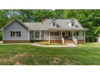 Charming home with a covered front porch, dormer windows, and a well-maintained lawn at 450 S Stratford Dr, Henderson, NC 27537