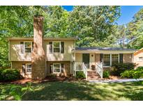 Charming two-story home featuring a brick chimney, shuttered windows, and a welcoming front entrance with stairs at 526 Colony Woods Dr, Chapel Hill, NC 27517