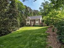 Charming brick two-story home with lush landscaping and a well-manicured lawn surrounded by mature trees at 5317 Deep Valley, Raleigh, NC 27606