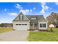 Charming new construction home featuring a two-car garage and a well-manicured front yard at 56 Birchtop Cir, Zebulon, NC 27597