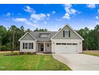 Inviting home exterior boasts a well-maintained lawn, attractive curb appeal, and an attached garage at 56 Birchtop Cir, Zebulon, NC 27597