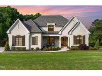 Charming two-story white brick home featuring manicured landscaping and a welcoming front porch at 8017 Discovery Falls Trl, Wake Forest, NC 27587