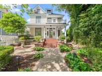 Inviting two-story home with charming curb appeal, lush landscaping, brick pathway and grand entrance with porch at 1000 Lamond Ave, Durham, NC 27701
