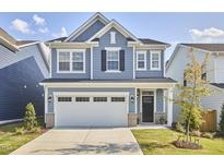 Charming two-story home features a two-car garage, lovely landscaping, and a classic blue exterior at 1021 Greatland Rd, Durham, NC 27703