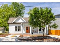Charming cottage-style home with a covered front porch and vibrant orange front door at 107 N Guthrie Ave, Durham, NC 27703