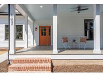 Charming front porch with an orange door, white columns, and a seating area at 107 N Guthrie Ave, Durham, NC 27703