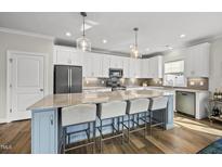 Bright kitchen features a large island with seating, granite countertops and stainless steel appliances at 110 Deacon Ridge Ln, Youngsville, NC 27596