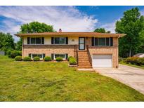 Charming two-story brick home with a well-maintained lawn and a single car garage at 117 Castlerock Dr, Durham, NC 27713