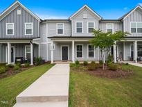 Charming townhome exterior featuring light gray siding, a covered porch, and a well-manicured front lawn at 1218 S Franklin St, Wake Forest, NC 27587