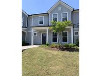 Charming townhome with light gray siding, a covered porch, and a well-manicured lawn at 1218 S Franklin St, Wake Forest, NC 27587