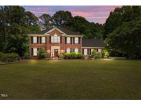 Beautiful two-story brick home with a manicured lawn and mature trees, perfect for curb appeal at 170 Homestead Rd, Angier, NC 27501