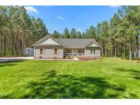 Charming single-story home featuring gray siding, symmetrical facade, and well-manicured lawn surrounded by mature trees at 1840 Willie Pace Rd, Burlington, NC 27217