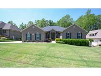 Charming brick home featuring a manicured lawn and lush landscaping at 197 W Paige Wynd Dr, Angier, NC 27501