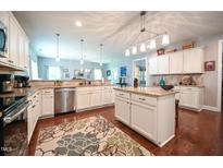 Spacious kitchen features granite countertops, stainless steel appliances and a large island at 197 W Paige Wynd Dr, Angier, NC 27501
