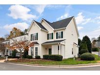 Charming two-story home featuring green shutters, well-manicured landscaping and a beautiful tree in the front yard at 2014 Silky Dogwood Trl, Apex, NC 27502