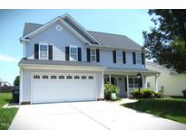 Charming two-story home with a large front lawn and an attached two-car garage at 202 Redstone Ct, Gibsonville, NC 27249