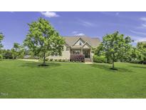Charming two-story home with lush landscaping, mature trees, and a well-maintained lawn at 25 Westbourne Ln, Youngsville, NC 27596