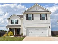 Charming two-story home featuring a two-car garage, neutral siding, and black shutters against a blue sky at 259 Brassfield Dr, Burlington, NC 27217