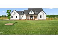 Charming two-story home features a spacious lawn, white siding, black roof, and inviting front porch at 2775 Eagles Roost Trl, Burlington, NC 27217