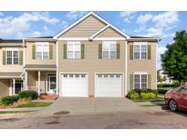 Charming townhome featuring two-car garage, green shutters, and well-maintained landscaping at 300 Sugar Maple Ave, Wake Forest, NC 27587